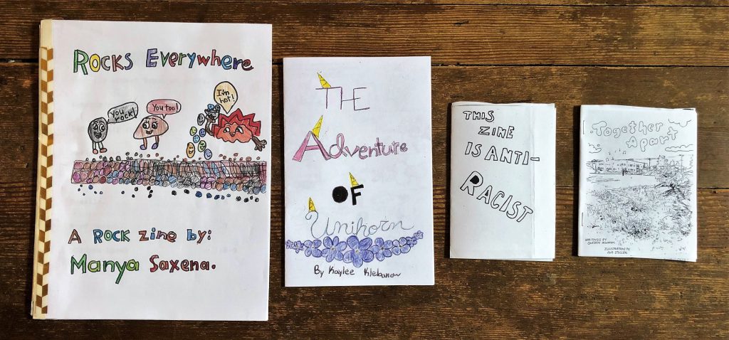a photo of the 4 winning zines for the 6th annual Washington State Zine Contest. Rocks Everywhere, The Adventure of Unihorn, This Zine is Antiracist, and Together Apart